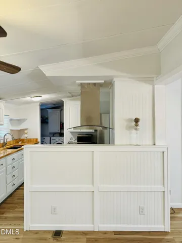 a view of a kitchen with kitchen island and stainless steel appliances
