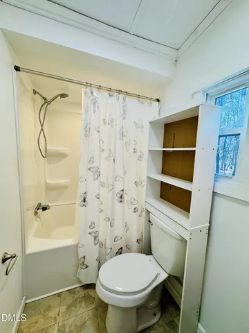 a bathroom with a toilet and a shower
