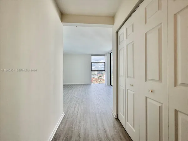 a view of a hallway with wooden floor and entryway