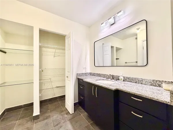 a bathroom with a sink vanity and a mirror