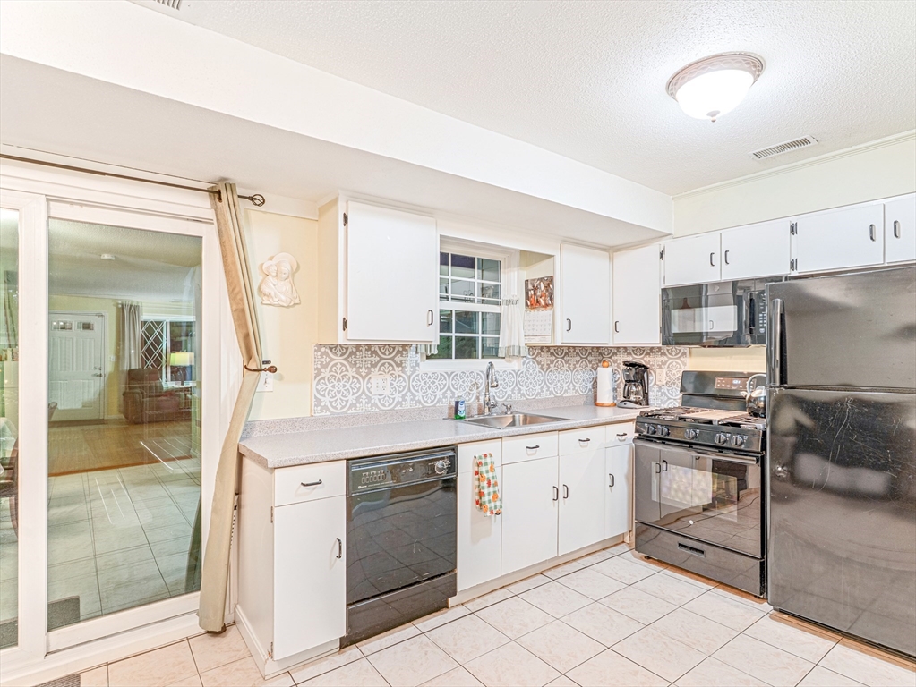 945 Riverside Drive, Unit 2A Methuen, MA 01844 - Photo 11 of 39 a kitchen with a sink stove and refrigerator