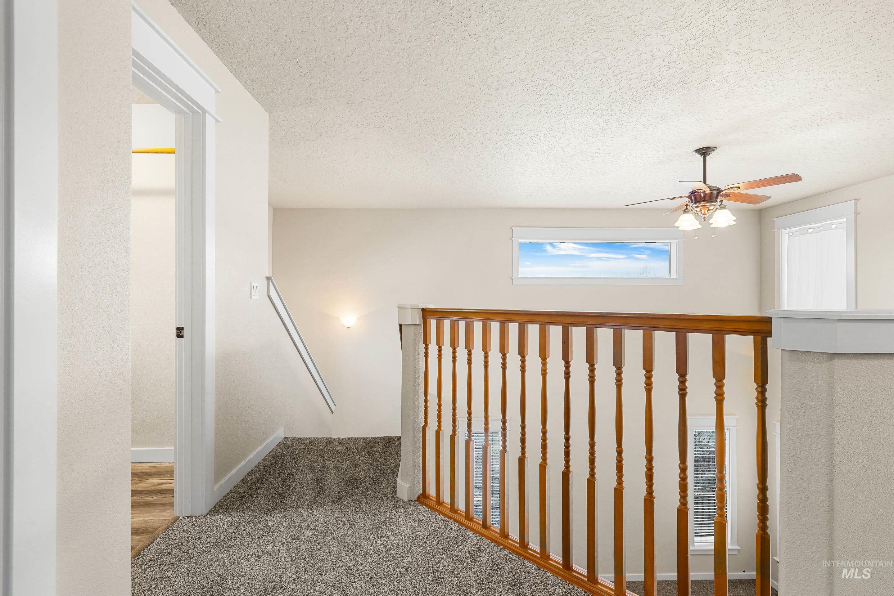 2578 South Groom Way Meridian, ID 83642 - Photo 18 of 39 Hall featuring carpet, a textured ceiling, and an upstairs landing