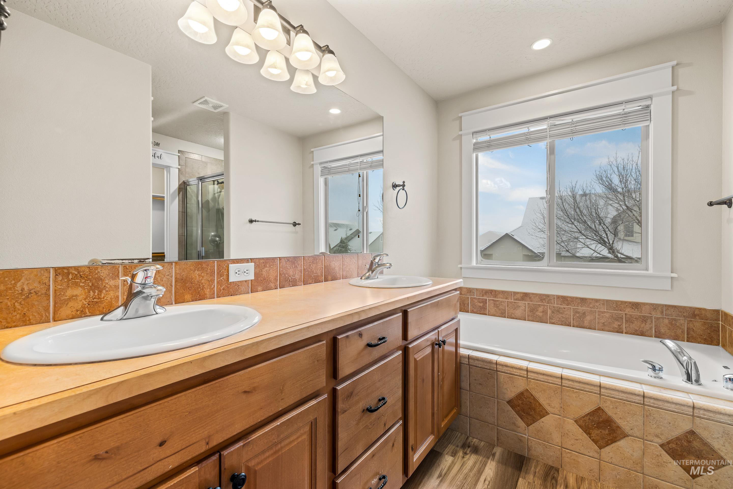 2578 South Groom Way Meridian, ID 83642 - Photo 21 of 39 Bathroom featuring a shower stall, double vanity, a garden tub, and light wood-style flooring
