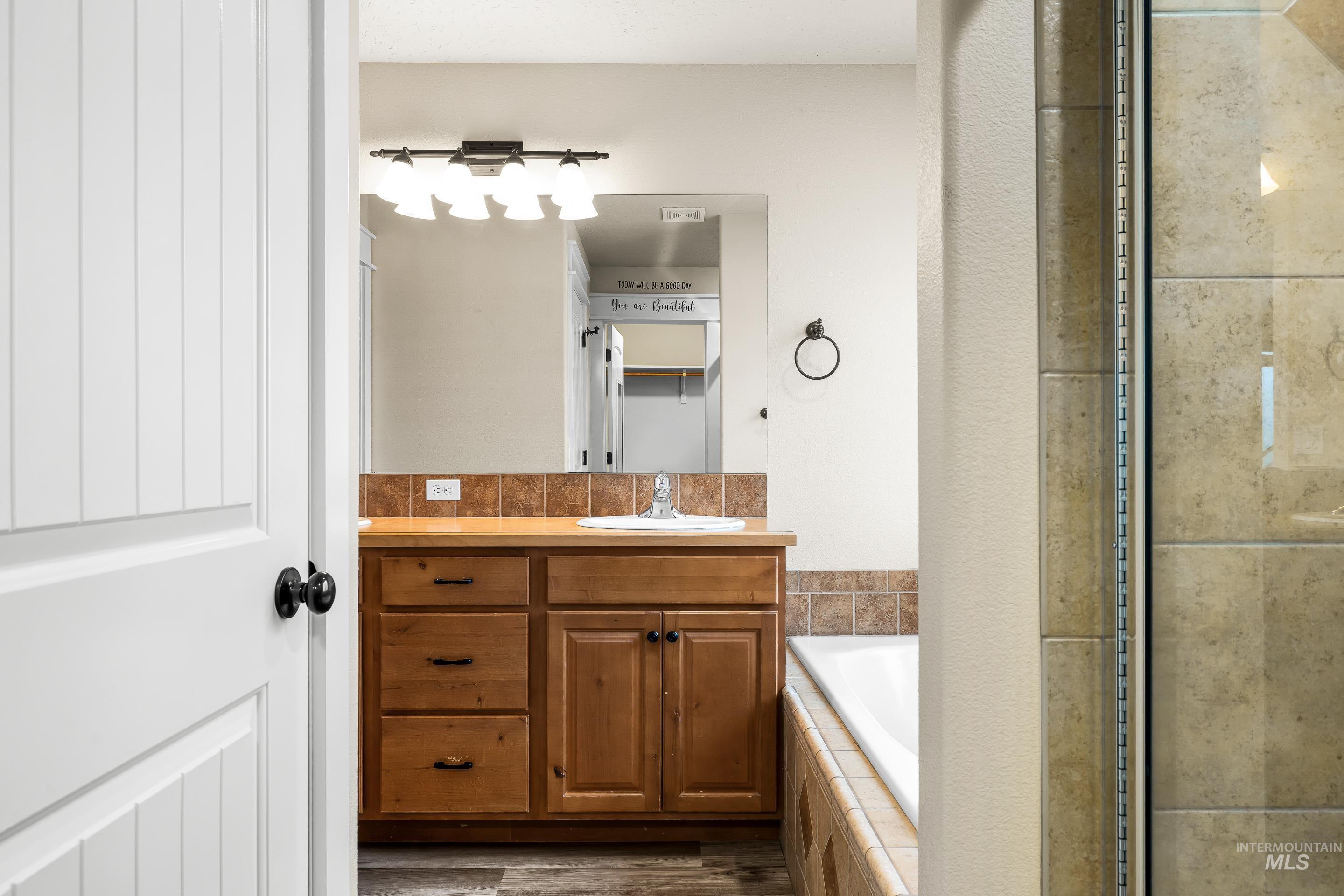 2578 South Groom Way Meridian, ID 83642 - Photo 25 of 39 Full bathroom with vanity, a garden tub, a shower stall, and wood finished floors