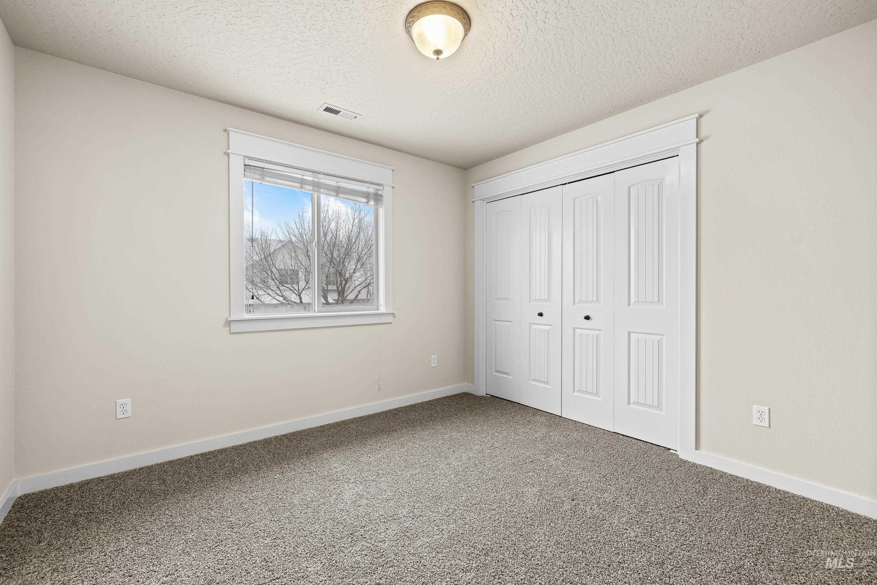 2578 South Groom Way Meridian, ID 83642 - Photo 26 of 39 Unfurnished bedroom featuring carpet floors, a textured ceiling, and a closet