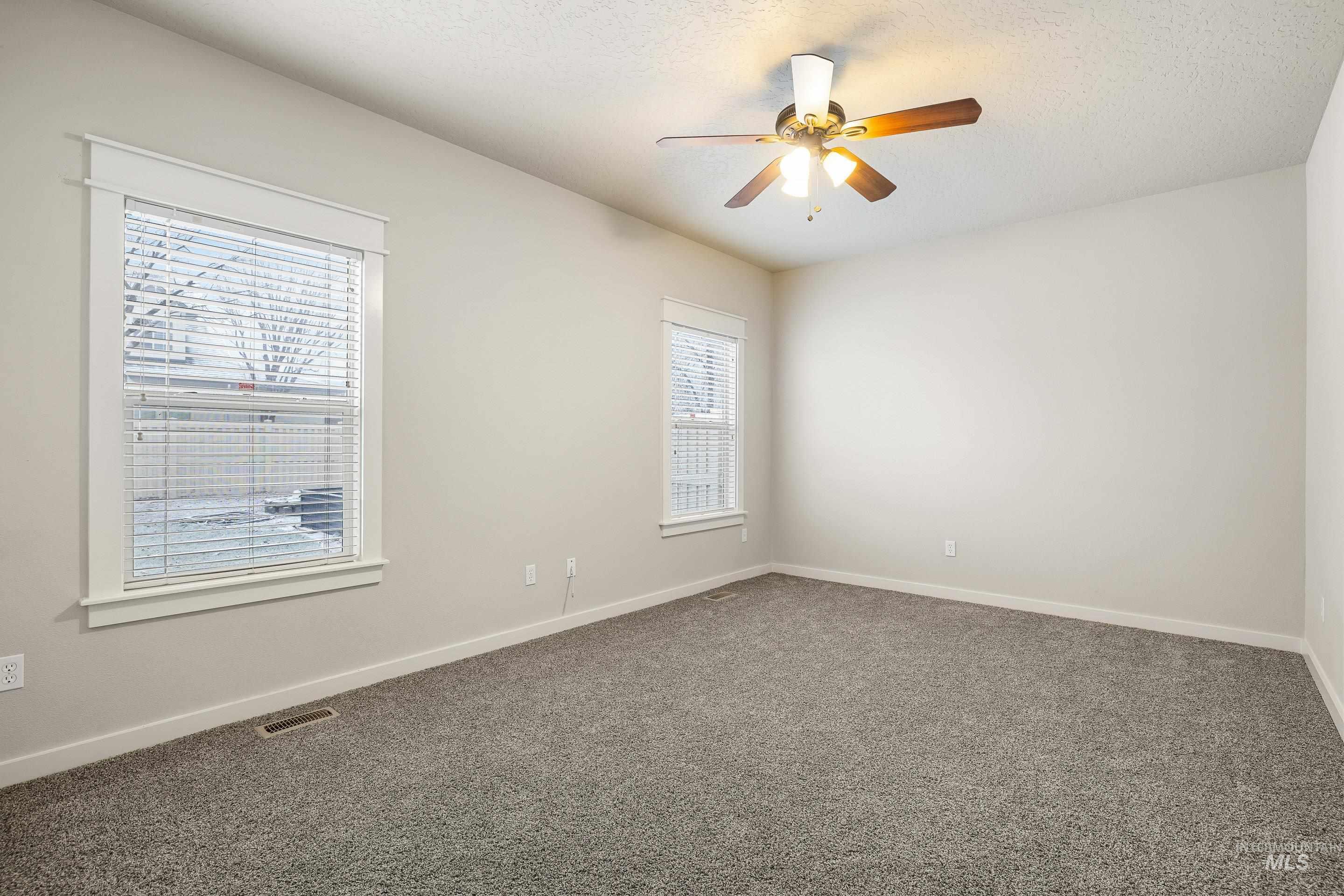 2578 South Groom Way Meridian, ID 83642 - Photo 30 of 39 Empty room featuring carpet floors, a textured ceiling, and a ceiling fan
