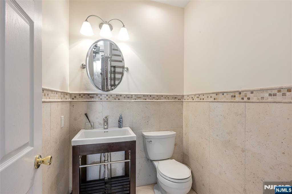682 Greeley Avenue, Unit A Fairview, NJ 07022 - Photo 13 of 23 a bathroom with a toilet a sink and a mirror