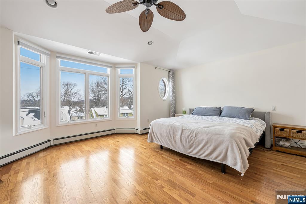 682 Greeley Avenue, Unit A Fairview, NJ 07022 - Photo 14 of 23 a spacious bedroom with a large bed and a large window