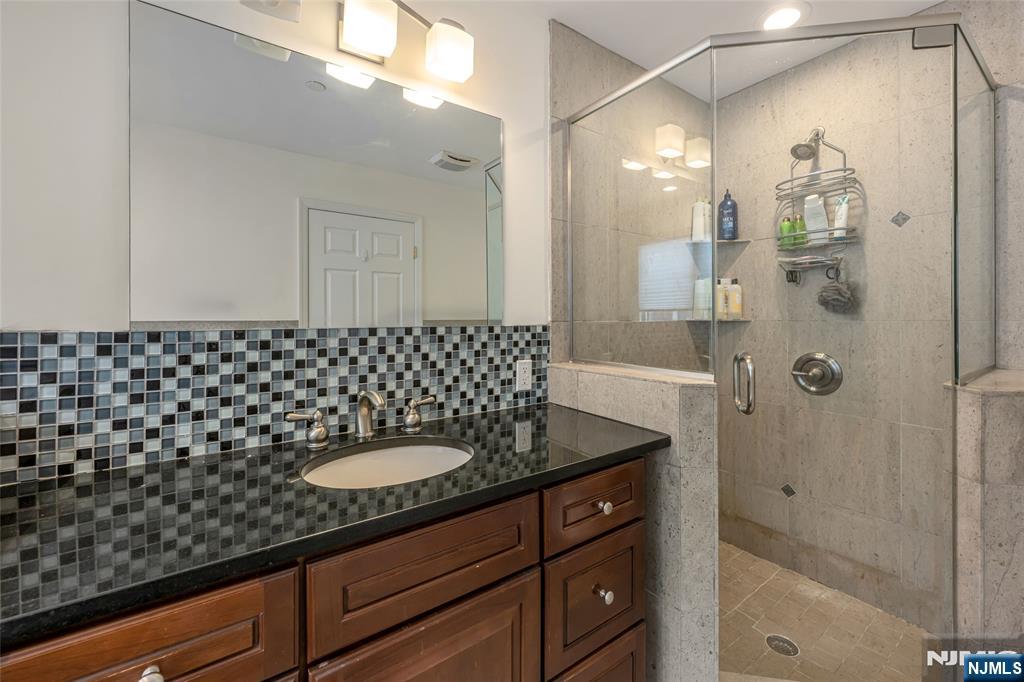 682 Greeley Avenue, Unit A Fairview, NJ 07022 - Photo 17 of 23 a bathroom with a sink a shower and a mirror