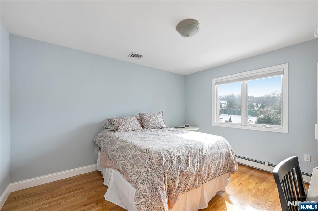 682 Greeley Avenue, Unit A Fairview, NJ 07022 - Photo 18 of 23 a bedroom with a bed and a window