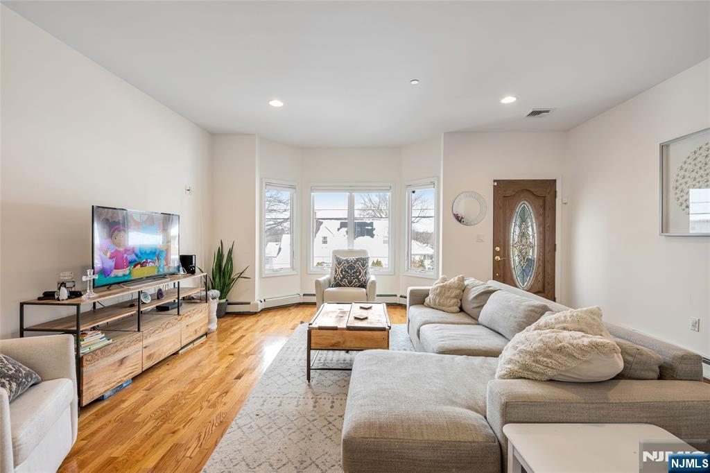 682 Greeley Avenue, Unit A Fairview, NJ 07022 - Photo 3 of 23 a living room with furniture flat screen tv and a large window