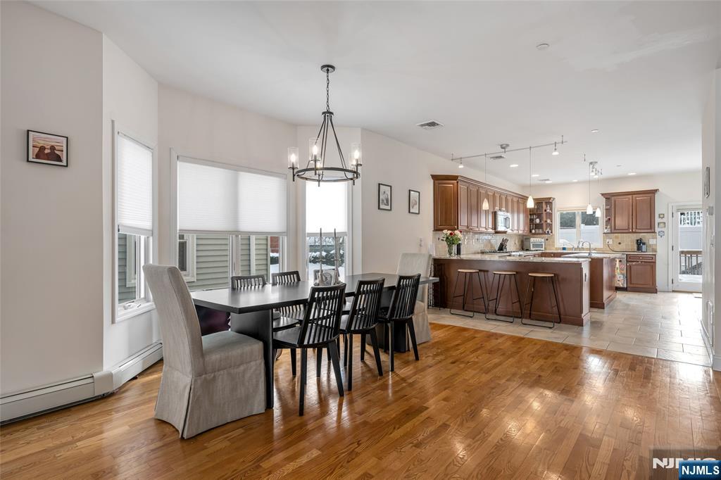 682 Greeley Avenue, Unit A Fairview, NJ 07022 - Photo 5 of 23 a view of a dining room and livingroom with furniture wooden floor a chandelier