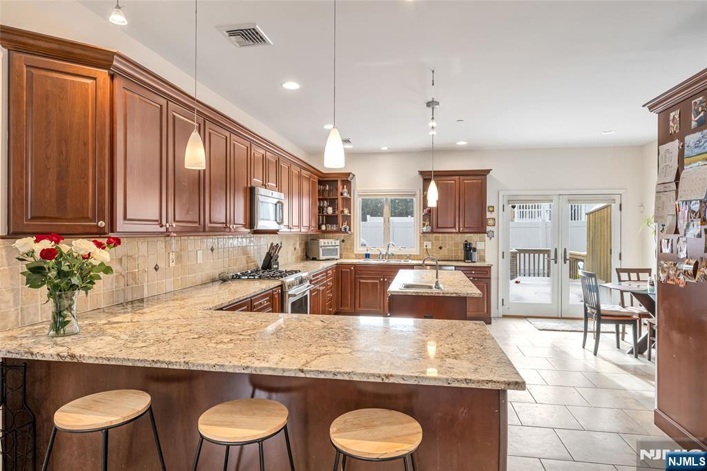 682 Greeley Avenue, Unit A Fairview, NJ 07022 - Photo 8 of 23 a kitchen with granite countertop lots of counter top space dining table and chairs