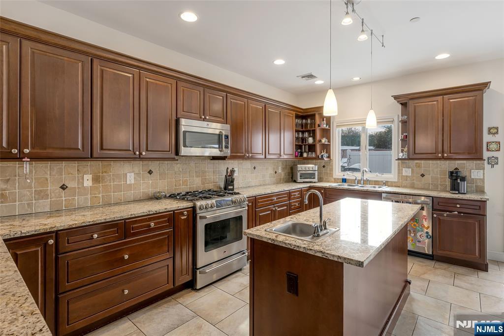 682 Greeley Avenue, Unit A Fairview, NJ 07022 - Photo 9 of 23 a kitchen with a sink stove top oven and cabinets