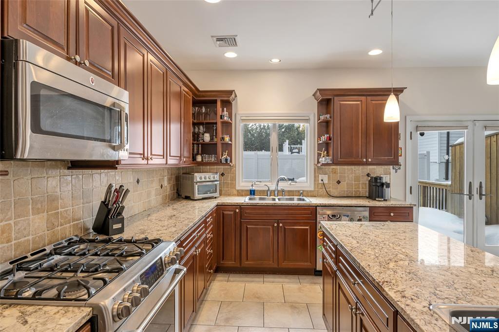 682 Greeley Avenue, Unit A Fairview, NJ 07022 - Photo 10 of 23 a kitchen with stainless steel appliances granite countertop a stove a sink and a microwave