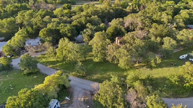 an aerial view of residential houses with outdoor space and trees