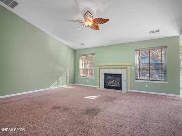 a view of an empty room with a fireplace and a window