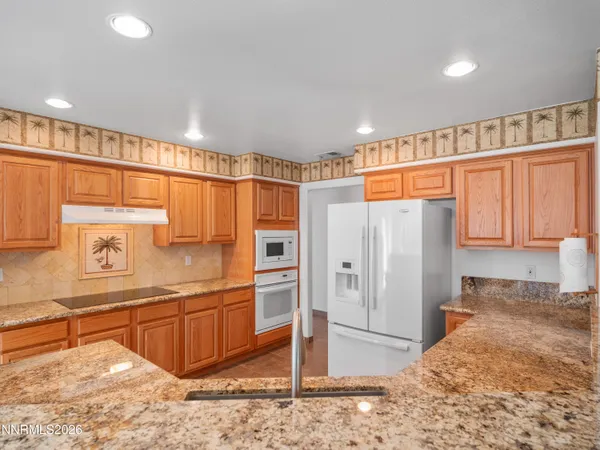 a kitchen with stainless steel appliances granite countertop a refrigerator and a sink