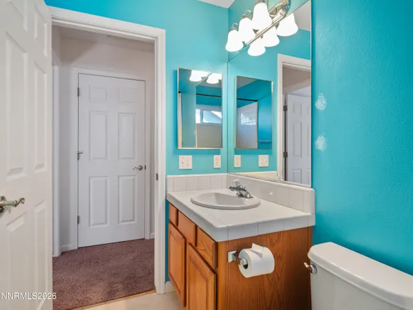 a bathroom with a sink a toilet and a mirror