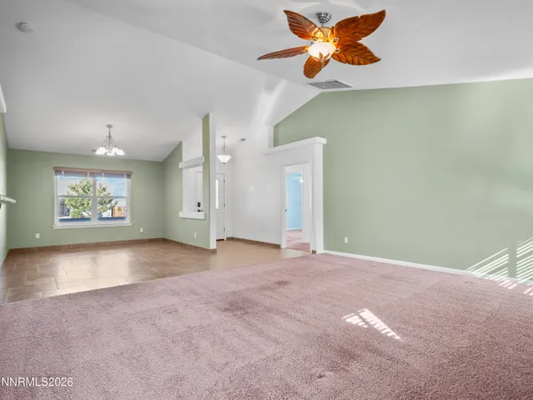a view of a big room with a ceiling fan and a window