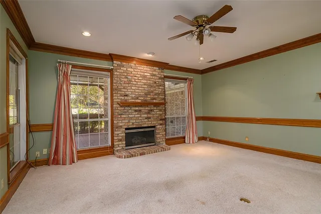 a view of empty room with fireplace and fan