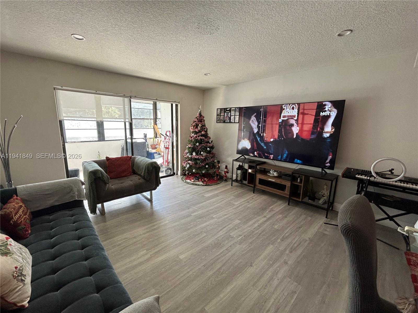 200 Gate Road, Unit 207 Hollywood, FL 33024 - Photo 11 of 38 a living room with furniture a flat screen tv and a window