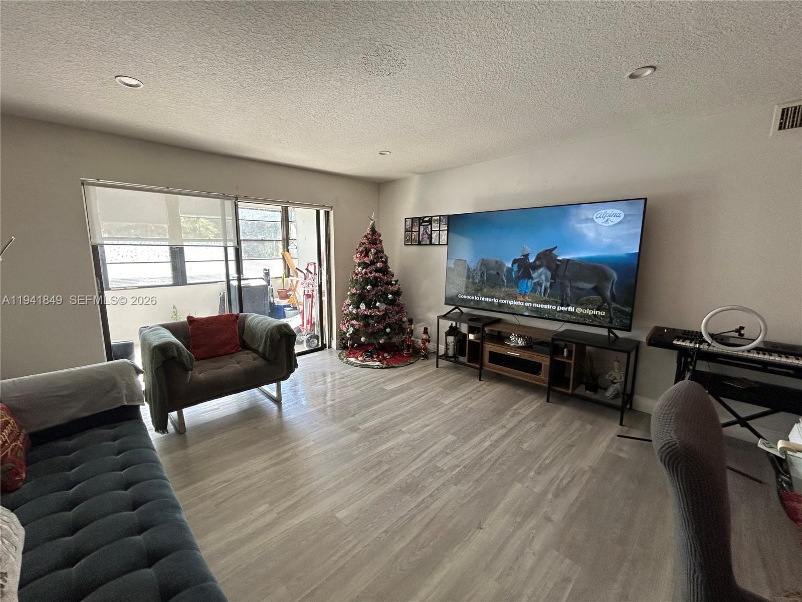 200 Gate Road, Unit 207 Hollywood, FL 33024 - Photo 12 of 38 a living room with furniture and a flat screen tv