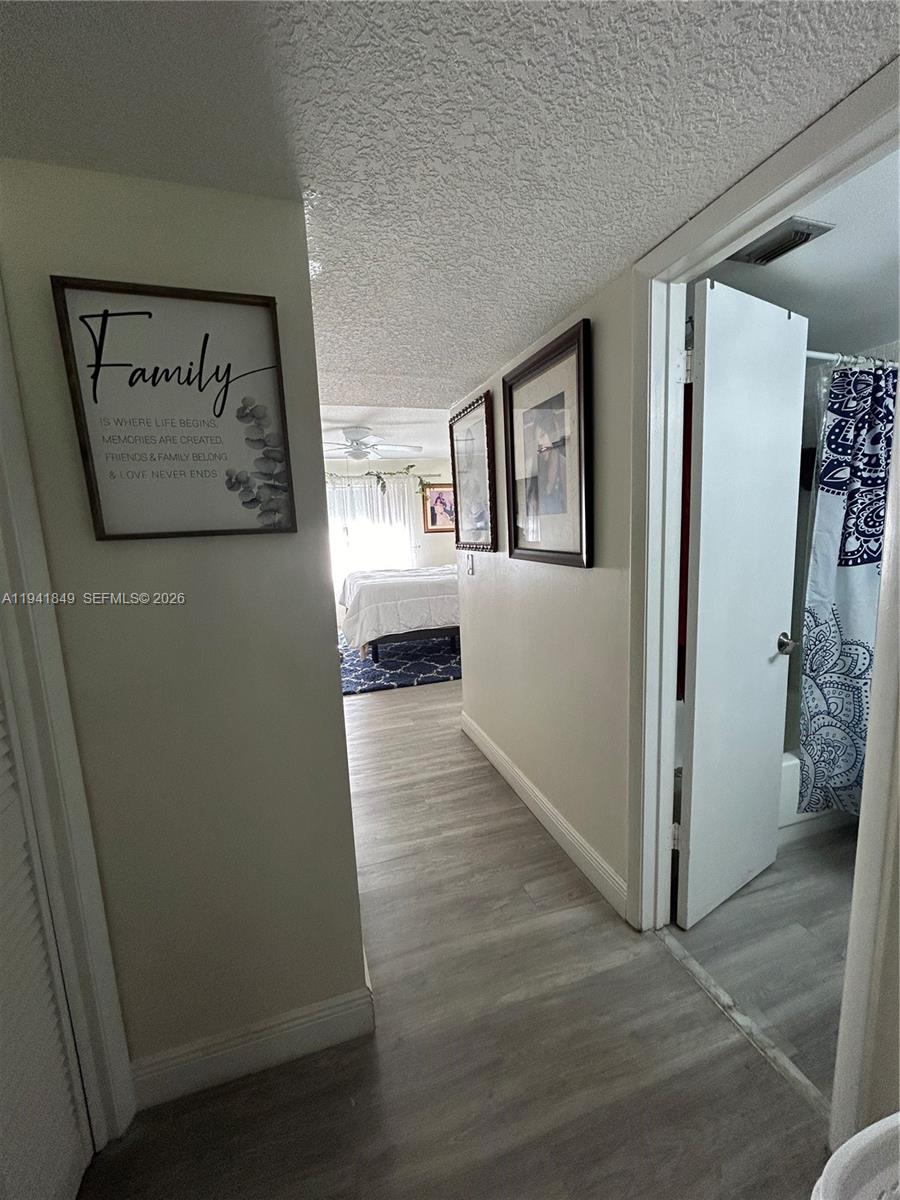 200 Gate Road, Unit 207 Hollywood, FL 33024 - Photo 21 of 38 a view of a hallway with wooden floor and a living room