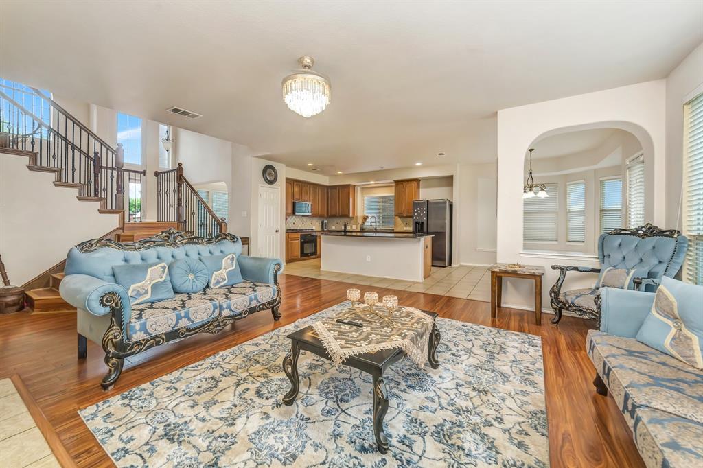 2312 Tawny Owl Road Grand Prairie, TX 75052 - Photo 13 of 40 Living room with hanging lights, light wood-style flooring, and arched walkways
