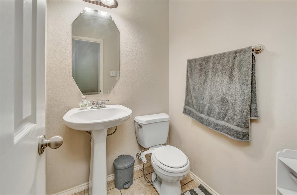 2312 Tawny Owl Road Grand Prairie, TX 75052 - Photo 24 of 40 Half bath with toilet and light tile patterned floors