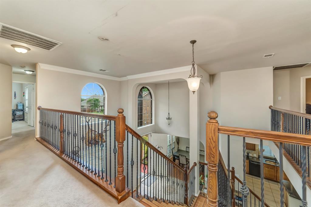 2312 Tawny Owl Road Grand Prairie, TX 75052 - Photo 25 of 40 Hallway featuring an upstairs landing, light carpet, and crown molding