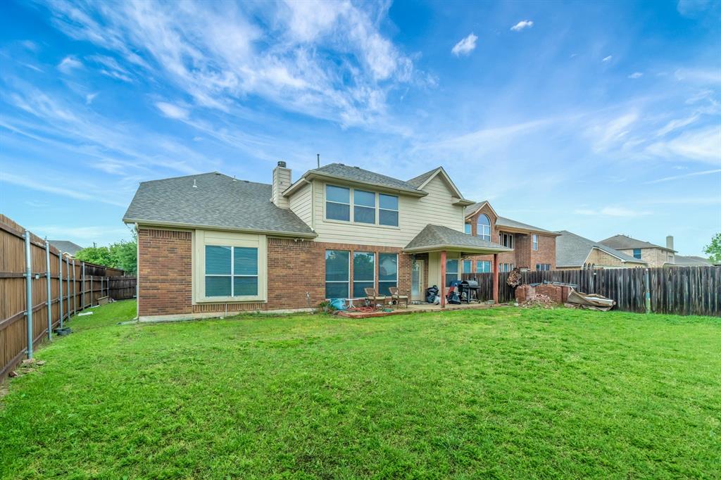 2312 Tawny Owl Road Grand Prairie, TX 75052 - Photo 33 of 40 Back of property with a patio, a fenced backyard, brick siding, and a chimney