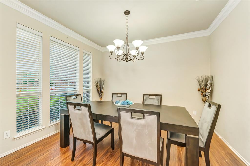 2312 Tawny Owl Road Grand Prairie, TX 75052 - Photo 5 of 40 Dining area with ornamental molding, a chandelier, and wood finished floors
