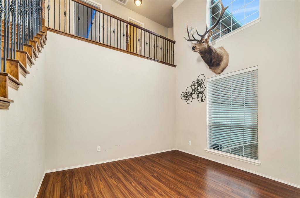 2312 Tawny Owl Road Grand Prairie, TX 75052 - Photo 6 of 40 Empty room with a high ceiling and dark wood-type flooring