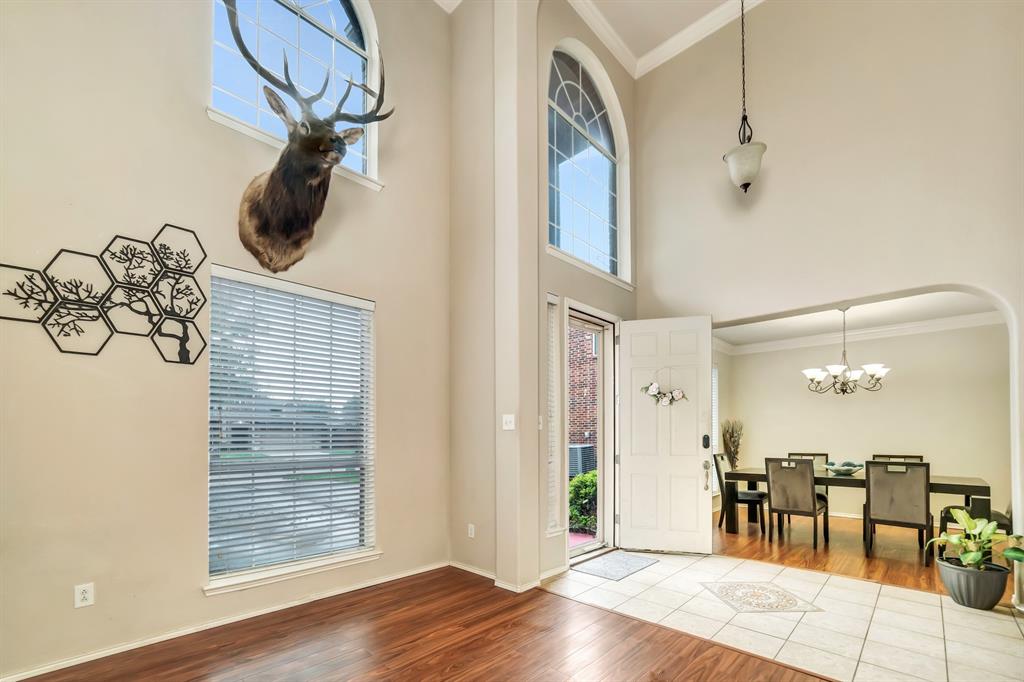 2312 Tawny Owl Road Grand Prairie, TX 75052 - Photo 7 of 40 Entryway with crown molding, hanging lights, wood finished floors, and a high ceiling