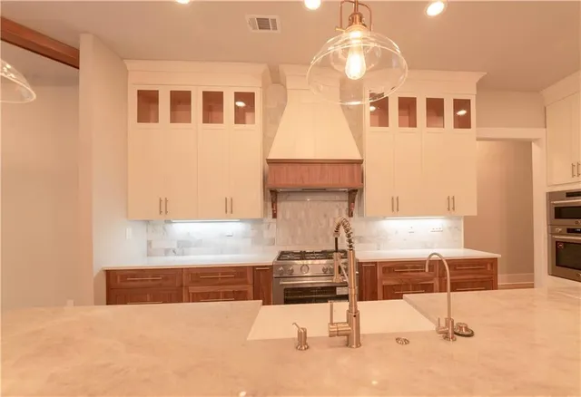 a kitchen with kitchen island cabinets and stove top oven