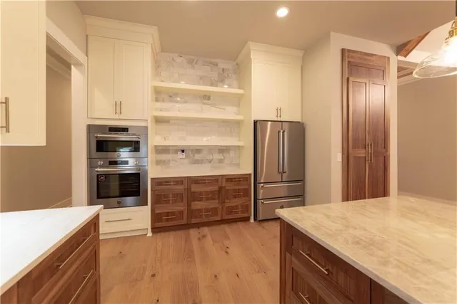 a kitchen with a refrigerator and a stove top oven
