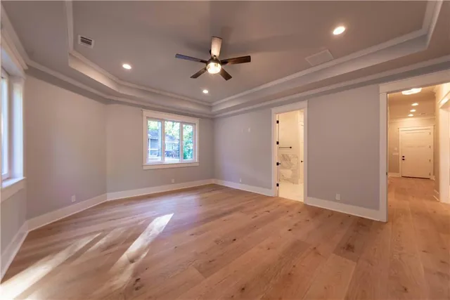an empty room with windows and ceiling fan