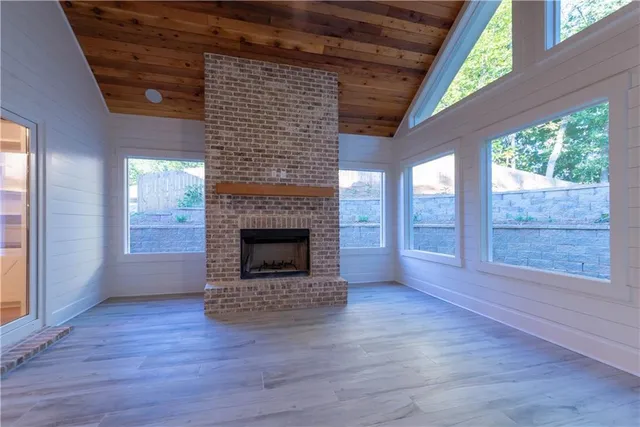 a view of empty room with wooden floor and fireplace
