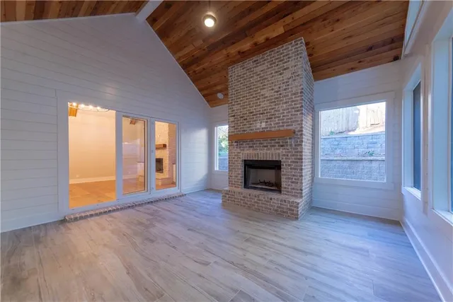 a view of empty room with wooden floor and fireplace