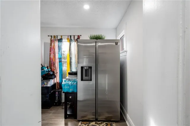 a kitchen with a refrigerator and a wooden floor