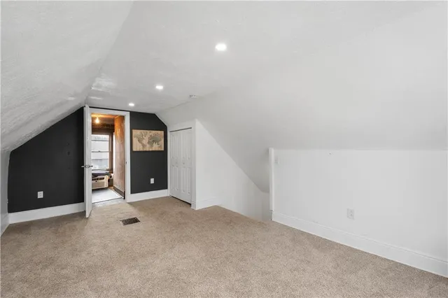 a view of an empty room with closet and bathroom