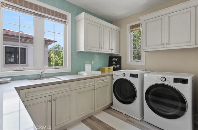 a kitchen with white cabinets and window