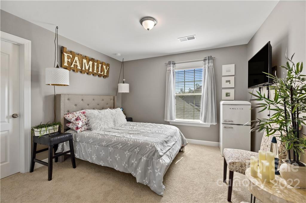 1908 Chatooka Lane Waxhaw, NC 28173 - Photo 44 of 47 a bedroom with a bed table chair and a flat screen tv