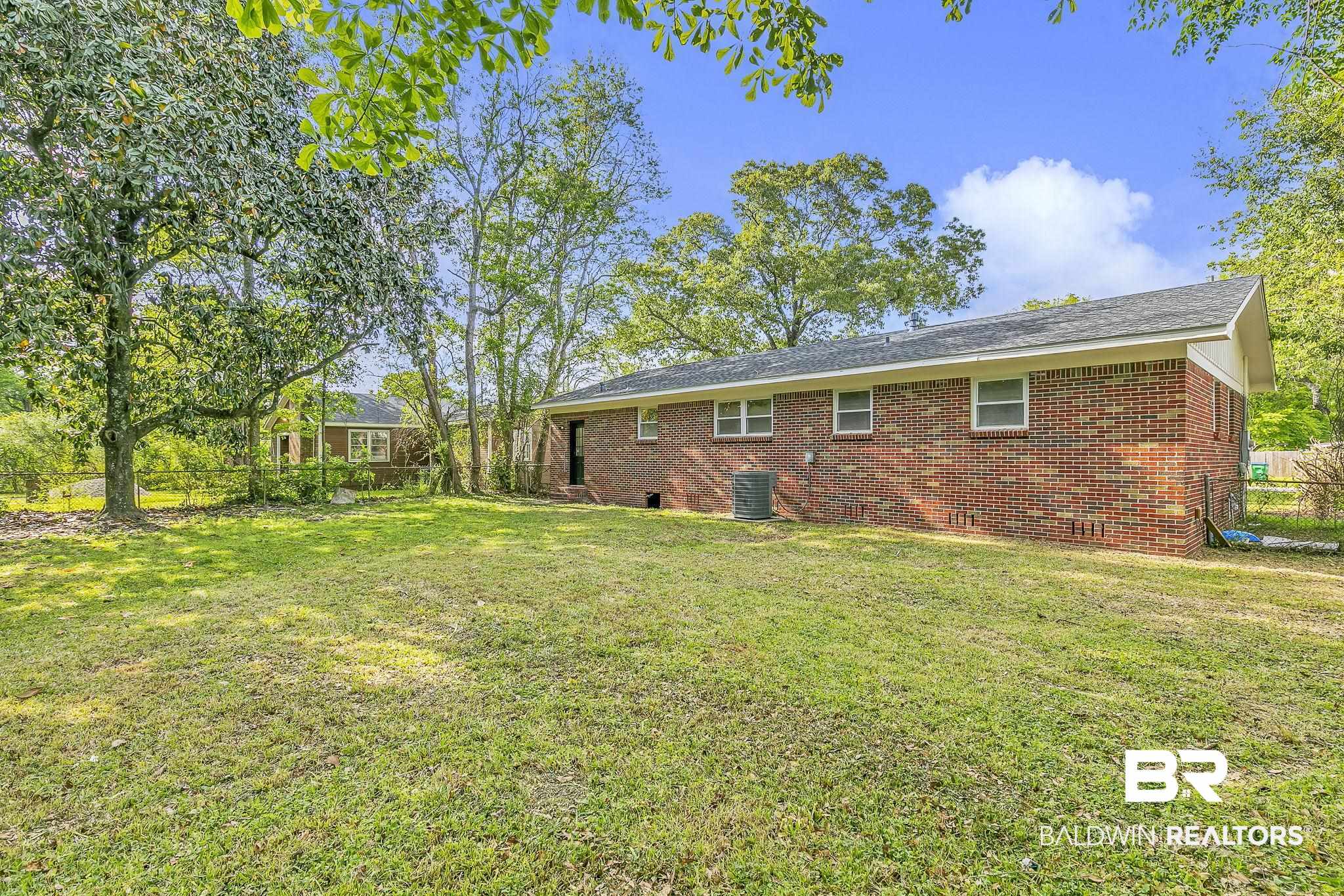 203 Anderson Road Saraland, AL 36571 - Photo 35 of 48 Rear view of property featuring central air condition unit, brick siding, fence, and a lawn