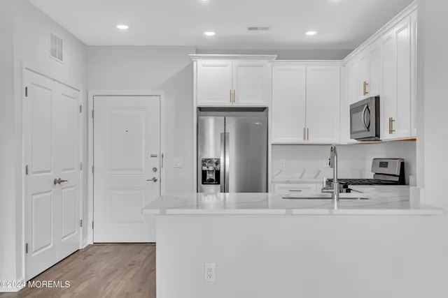 a kitchen with stainless steel appliances granite countertop a refrigerator and a stove top oven