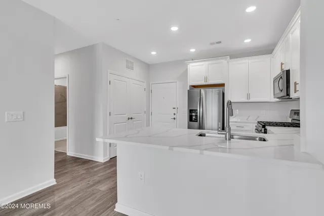 a large white kitchen with stainless steel appliances