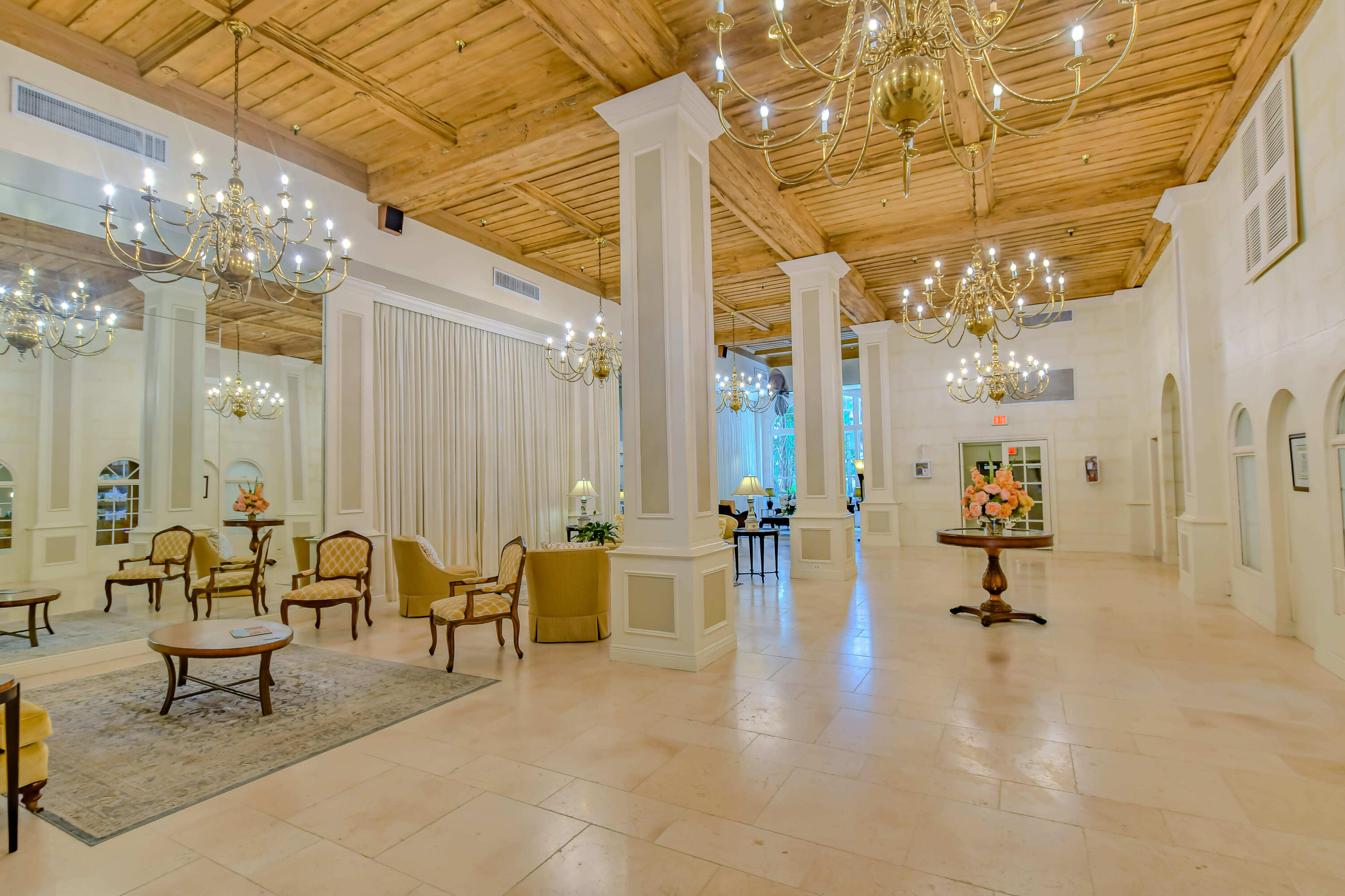 235 Sunrise Avenue, Unit 1050 Palm Beach, FL 33480 - Photo 25 of 29 a living room with couches and kitchen view with chandelier