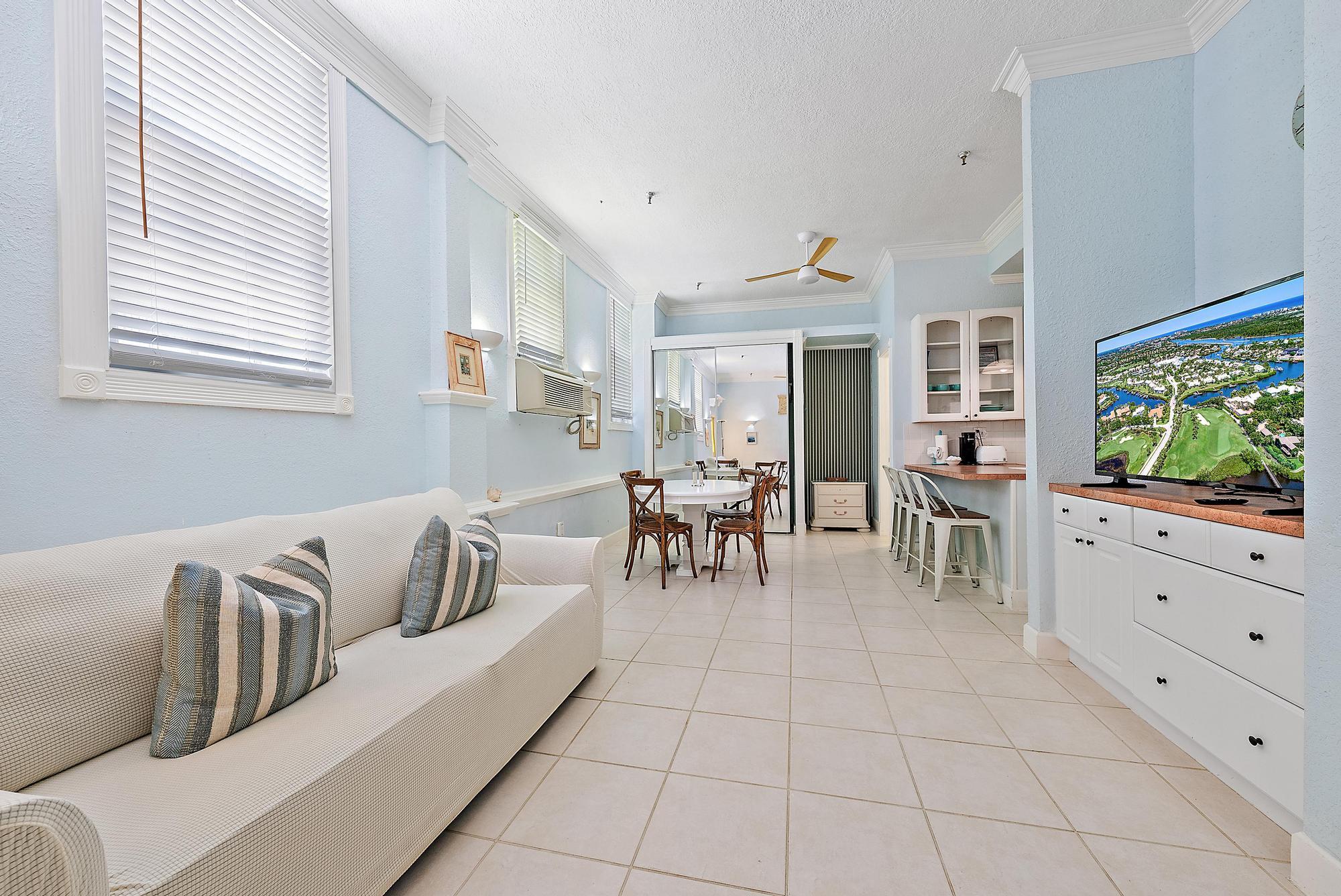 235 Sunrise Avenue, Unit 1050 Palm Beach, FL 33480 - Photo 5 of 29 a living room with furniture and a flat screen tv
