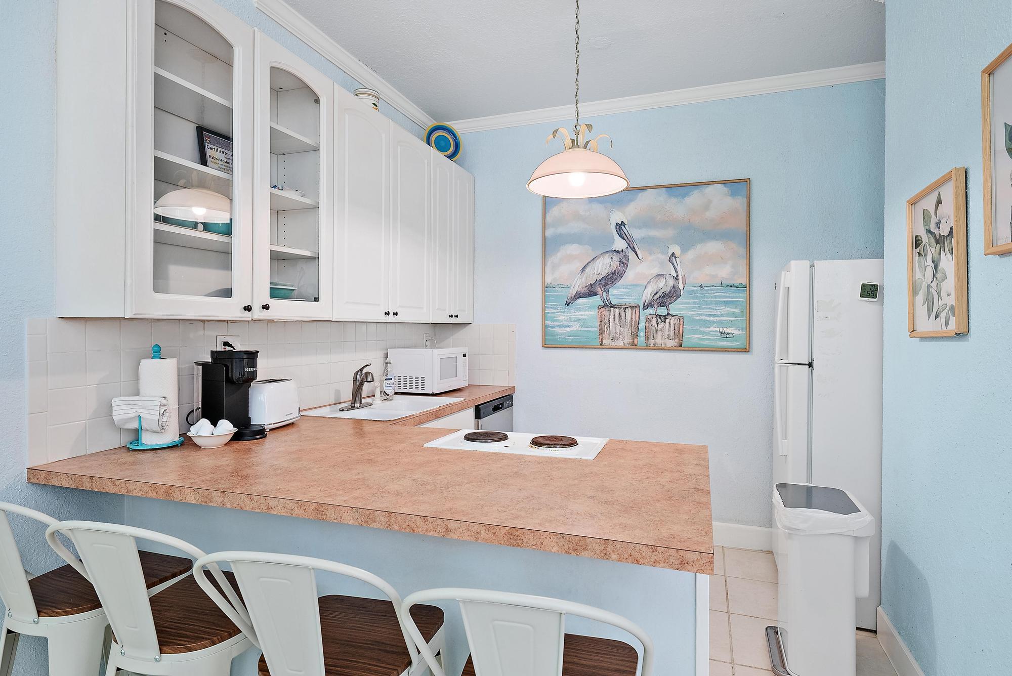 235 Sunrise Avenue, Unit 1050 Palm Beach, FL 33480 - Photo 8 of 29 a dining table with white cabinets and wooden floor